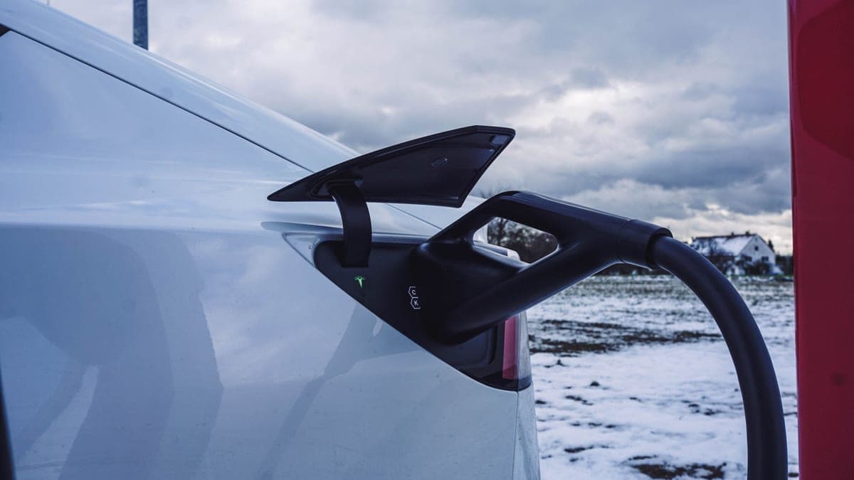 An electric car parked and charging in snowy winter conditions