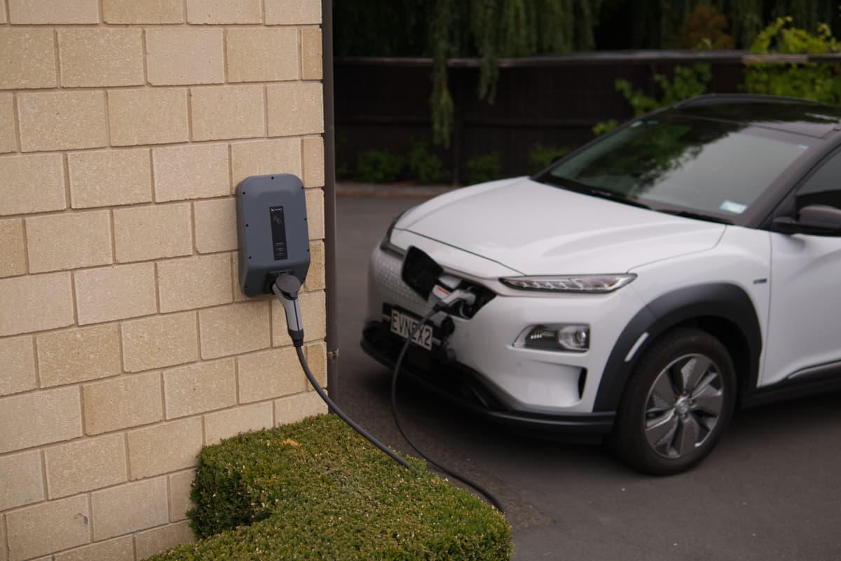 An electric car charging outdoors on a residential driveway